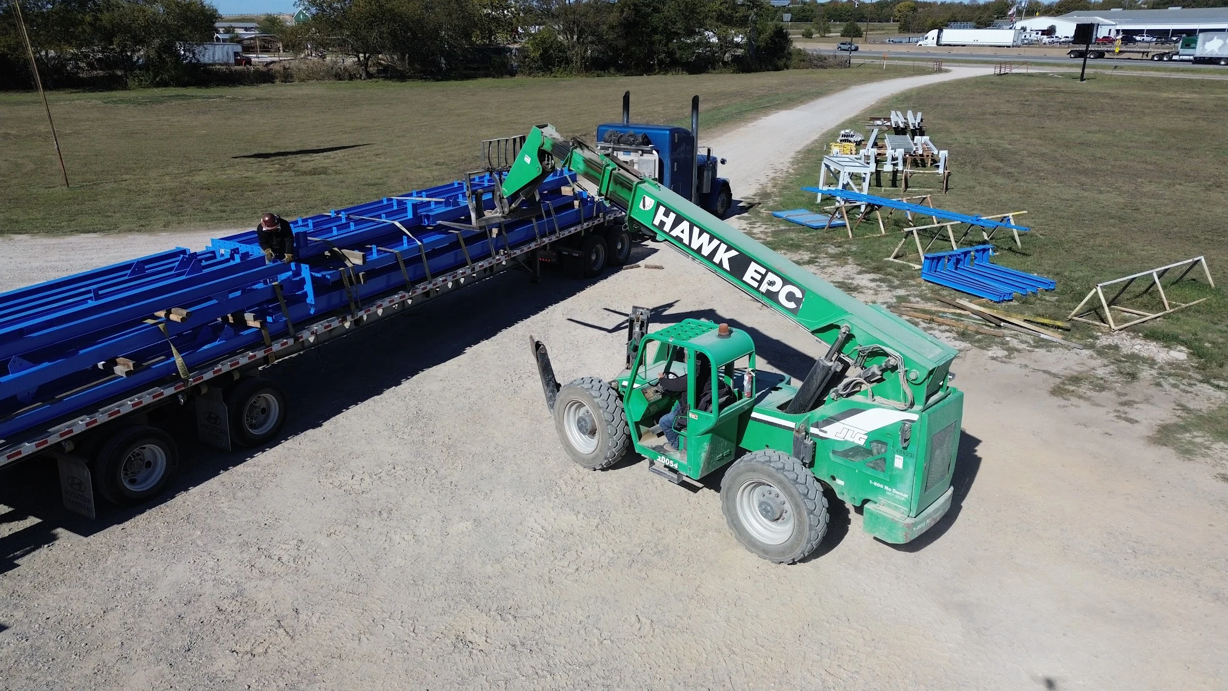 Telehandler loading fabricated steel onto a truck