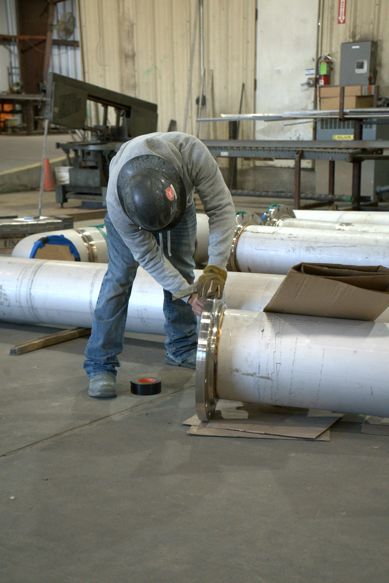 Fitter setting a flange on pipe at the Hawk Fabrication shop