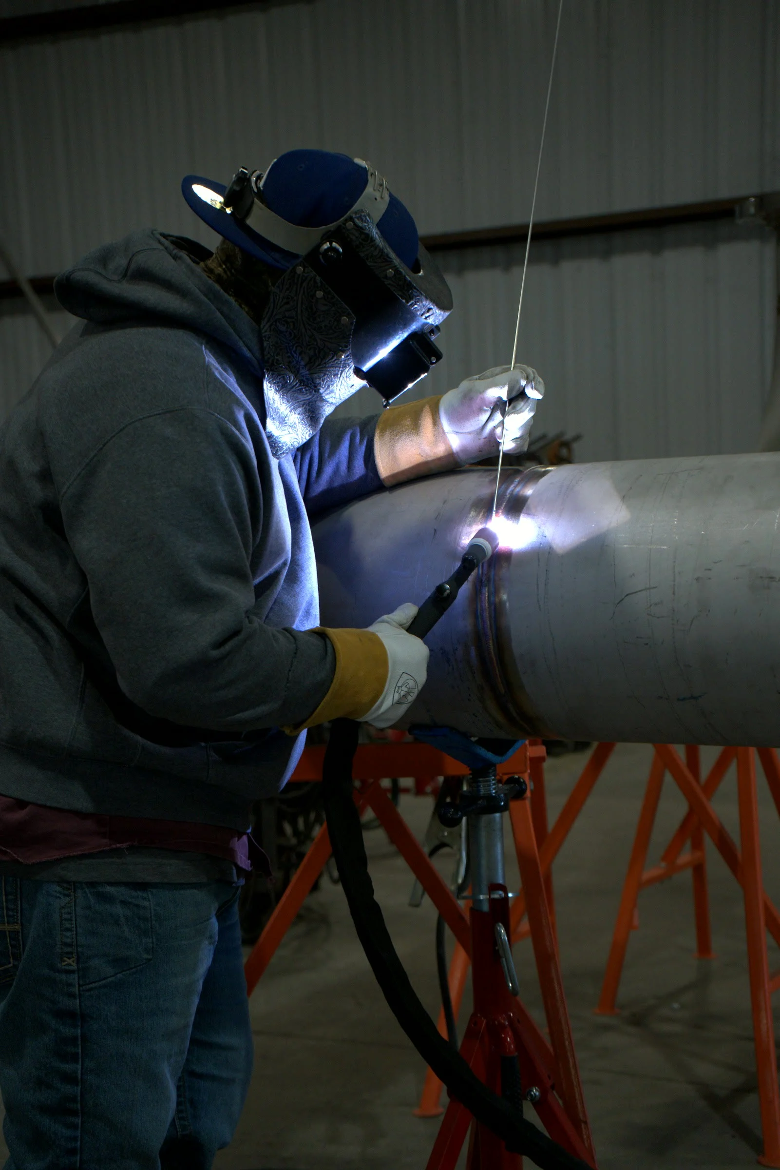 Welder running a pass on a pipe spool at the Hawk Fabrication shop